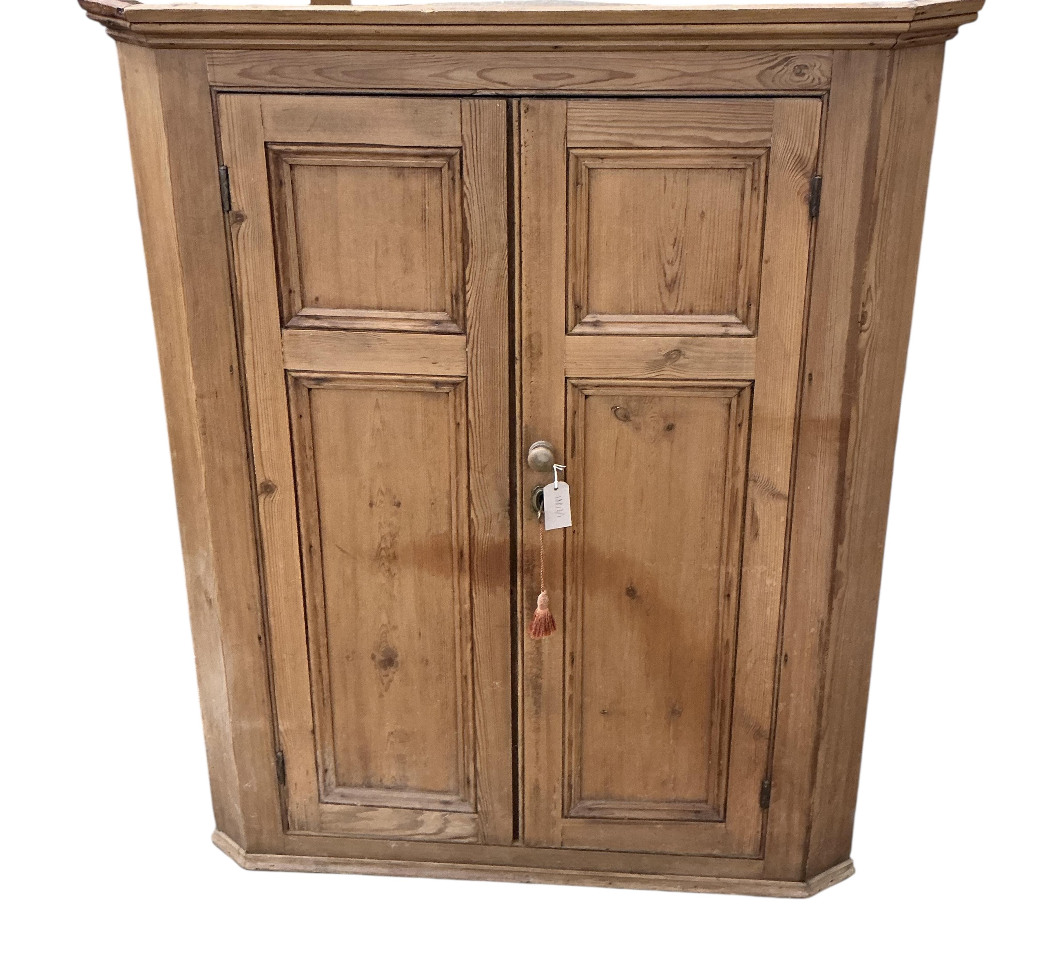 A Victorian panelled pine hanging corner cabinet, width 102cm, depth 53cm, height 126cm